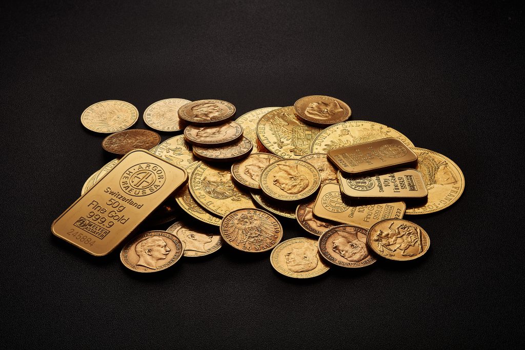 assorted gold bars and coins on a table