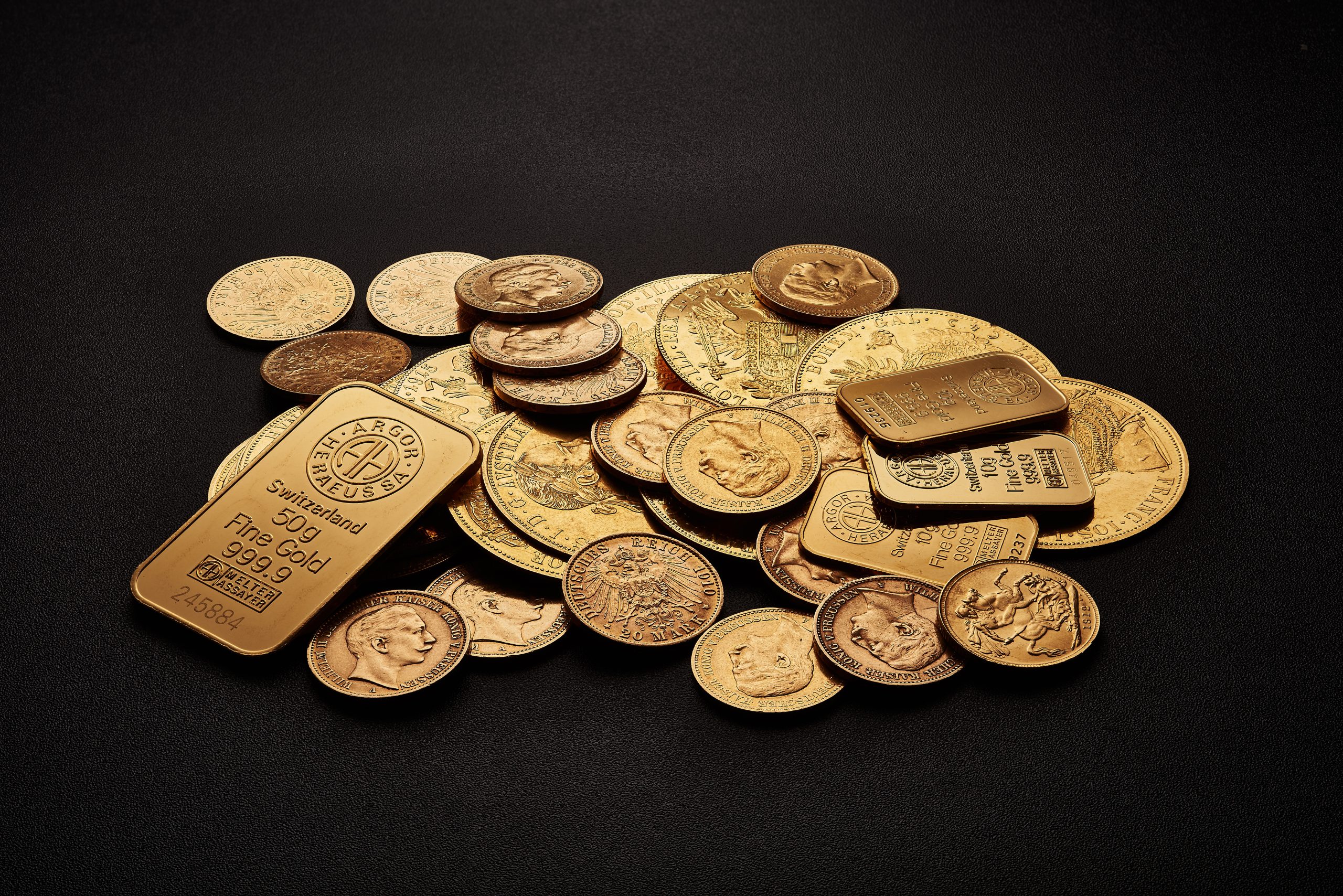 assorted gold bars and coins on a table